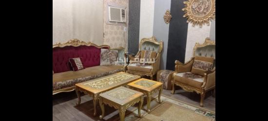 كنب مع الطاولات وادوات الزينة على الحائط